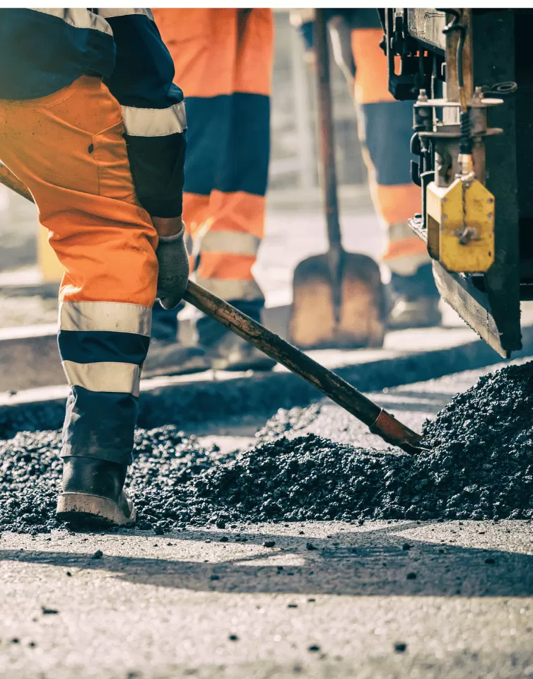 Worker spreading driveway surfacing material