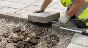 man laying blocks on a new driveway