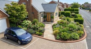 Overhead-angle view of a well-planned front garden driveway showing a parked car