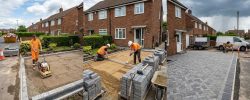 Professional team installing a driveway at a North East home during changeable July weather