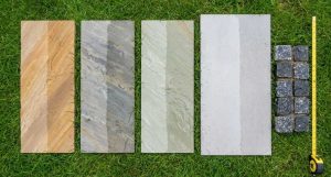 Indian sandstone and porcelain paving samples laid out on grass for comparison