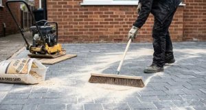 Kiln-dried sand being brushed into block paving joints after cleaning
