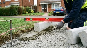 Concrete edging kerbs being bedded on a compacted driveway sub-base