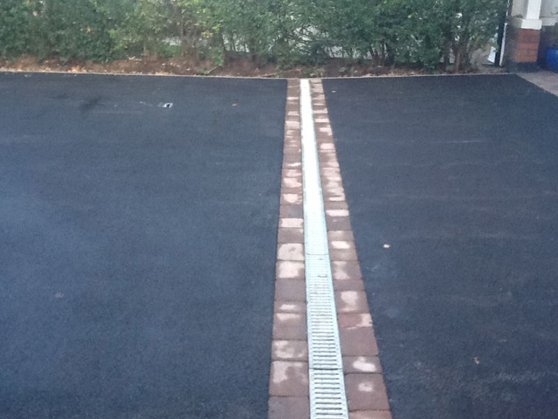 Finished tarmac driveway with a drainage channel