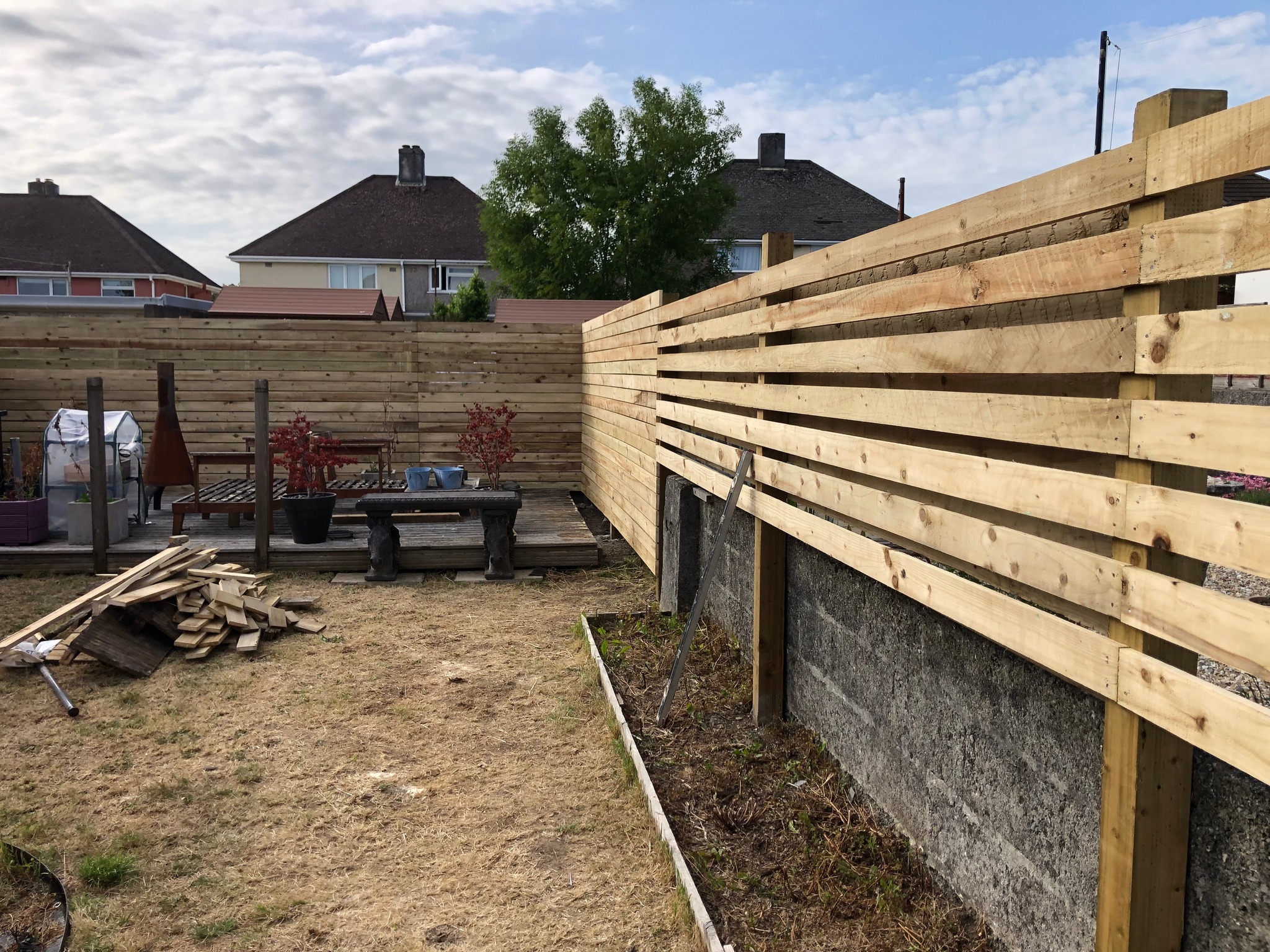 Horizontal timber garden fencing with planted borders and decking