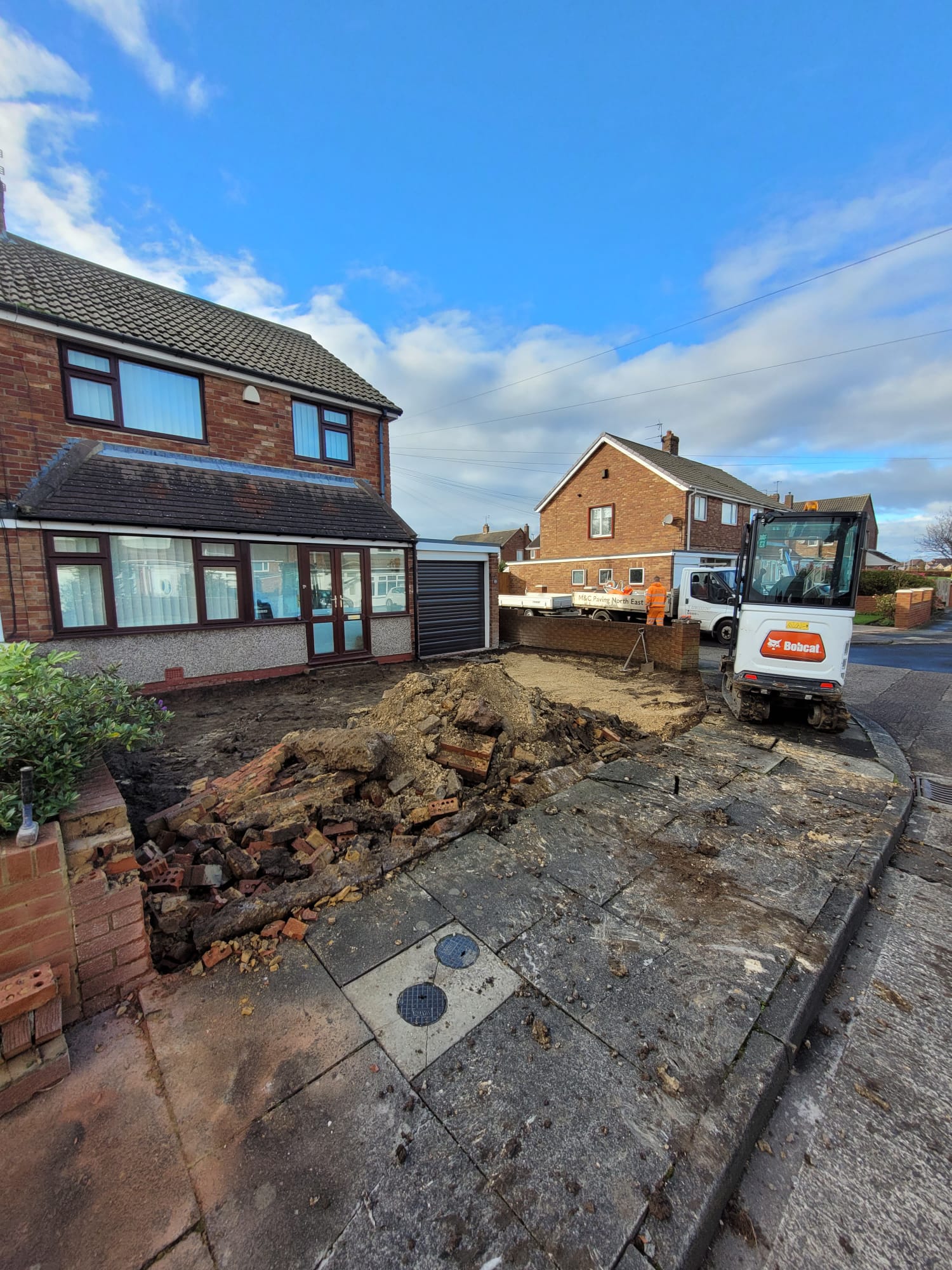 Driveway excavation and preparation beside a house