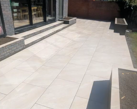 Porcelain patio with steps beside the home