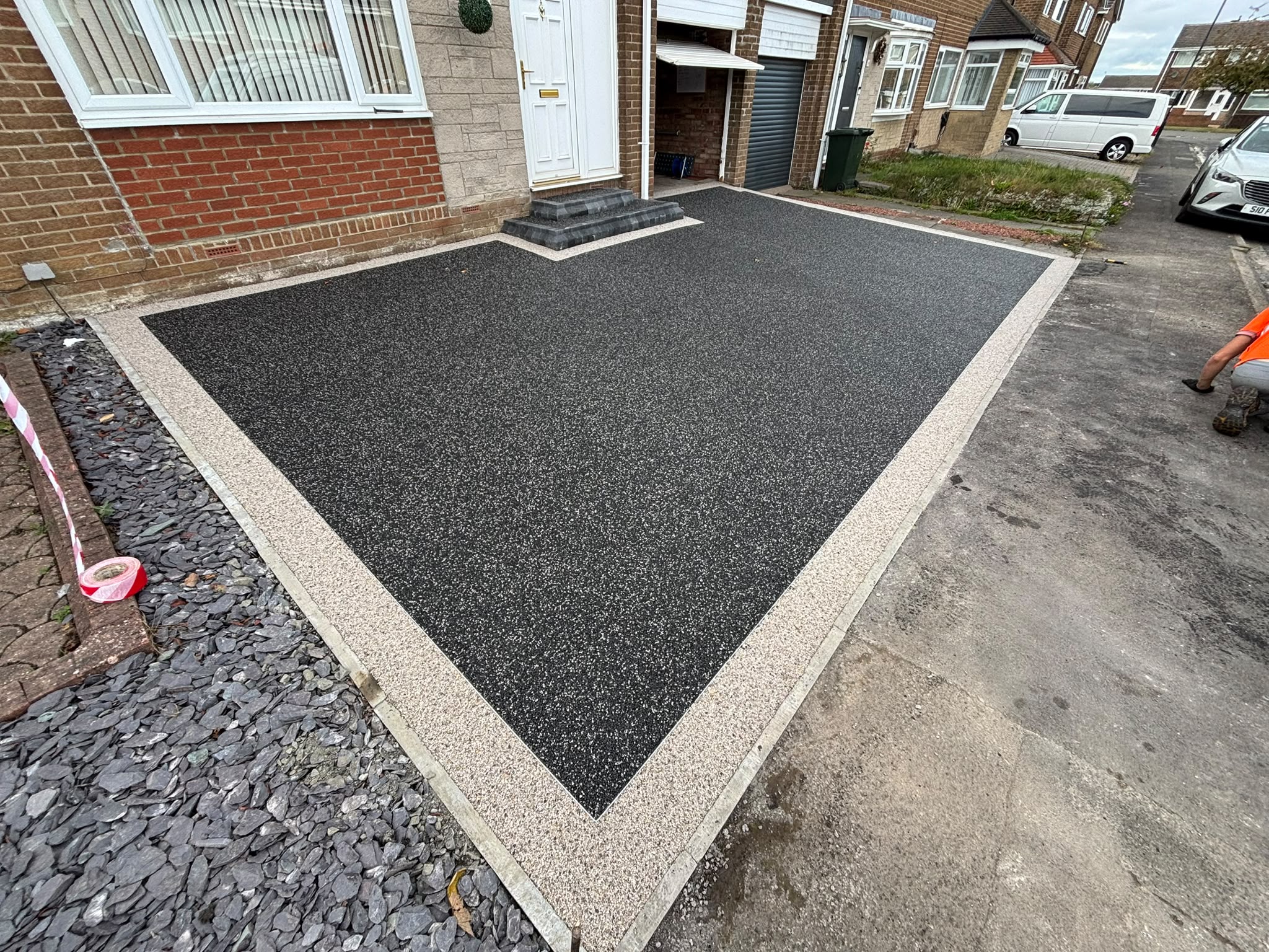 Resin driveway with pale edging and slate garden border